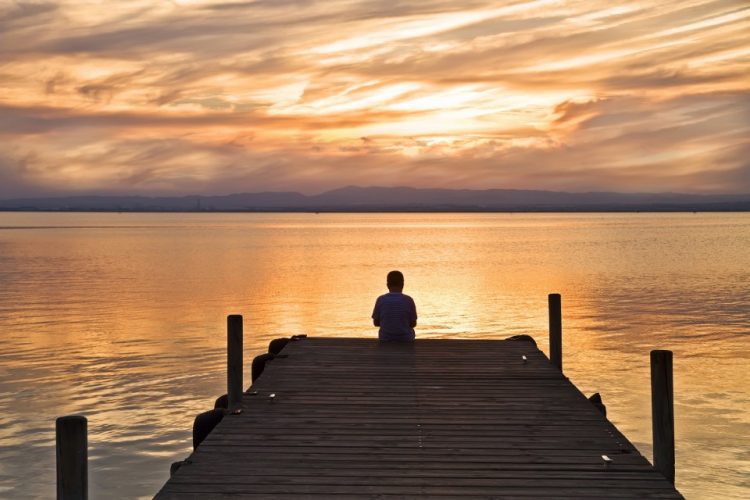 uma pessoa sentada na ponte pensando sobre nunca se casar