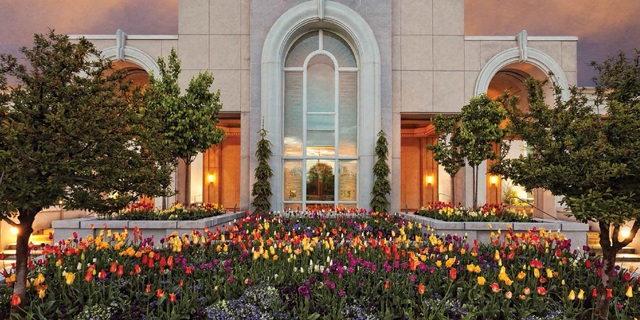 Jardim do templo com diversas flores de cores amarela, vermelha, laranja, e rosa.