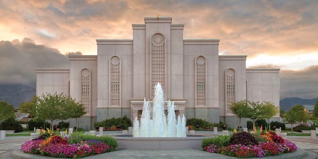 sob o céu de cor rosa perolado, vemos o templo com uma fonte de água no meio de dois jardins com muitas flores