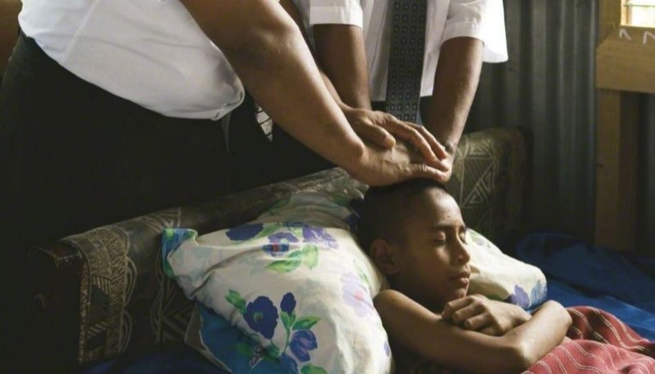 Portadores do sacerdócio dando uma bênção em um menino. 