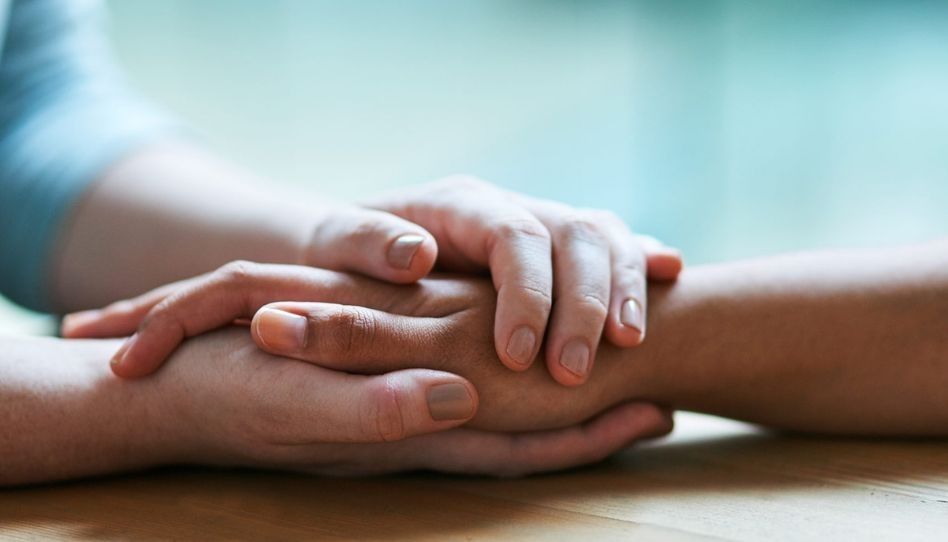 Mãos de duas pessoas juntas.