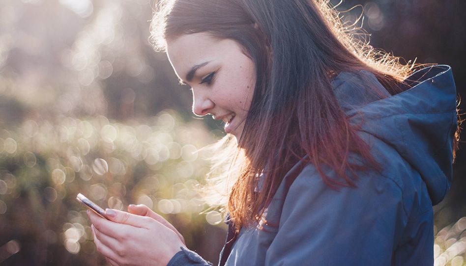 Menina mexendo no celular.