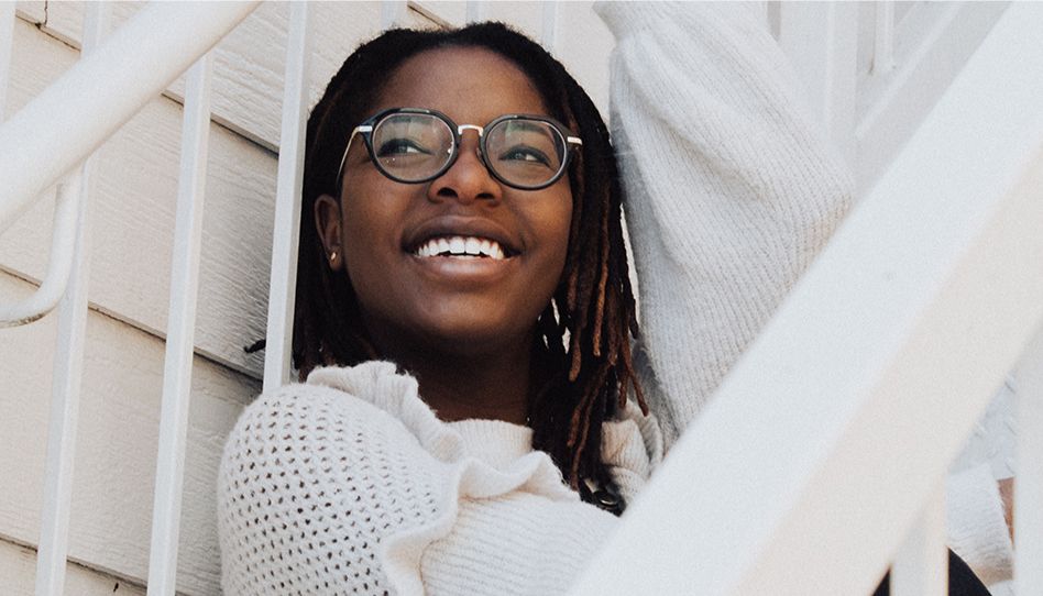 Menina sorrindo olhando para o horizonte. 