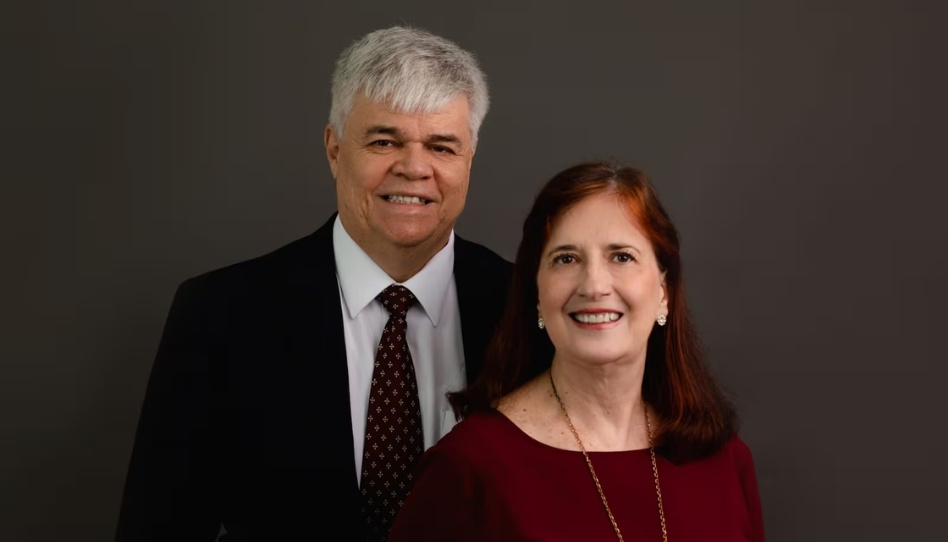Presidente e diretora posando juntos em seus trajes dominicais