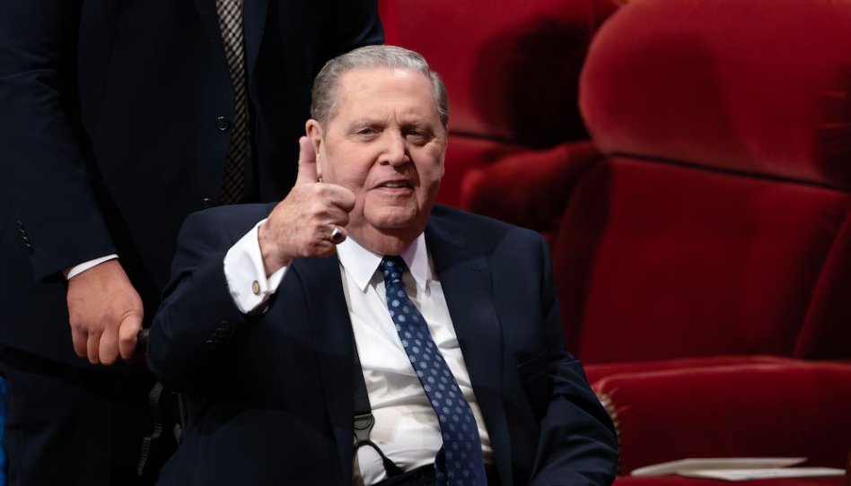 Elder Jeffrey R. Holland levanta o polegar em sinal de ânimo e fé, demonstrando esperança em meio à adversidade.