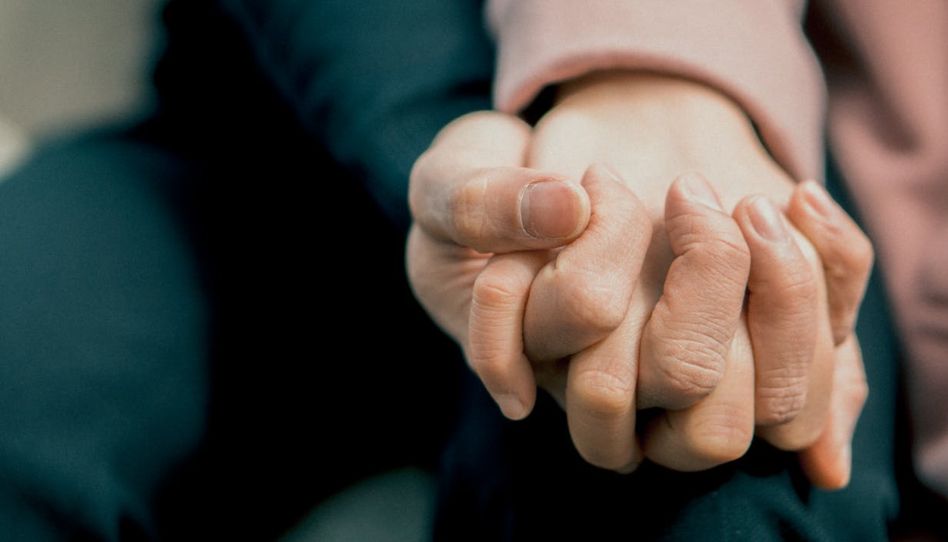 Mãos dadas entre duas pessoas.