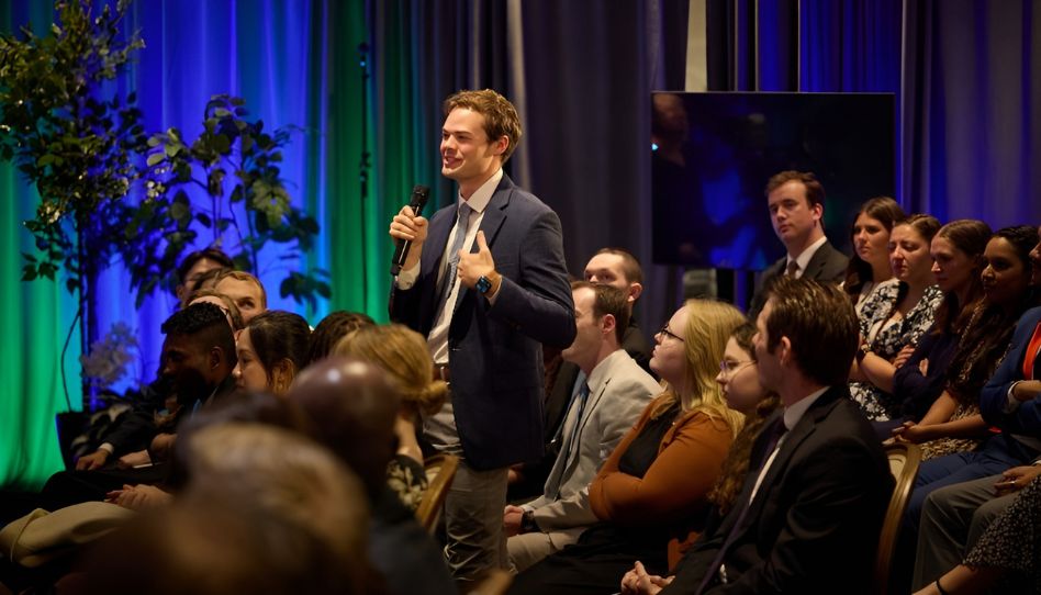 Um jovem adulto faz uma pergunta ao Élder Neil L. Andersen e à sua esposa, Kathy, após o casal ter discursado nos jardins do Templo de Washington D.C., em 18 de outubro de 2025.