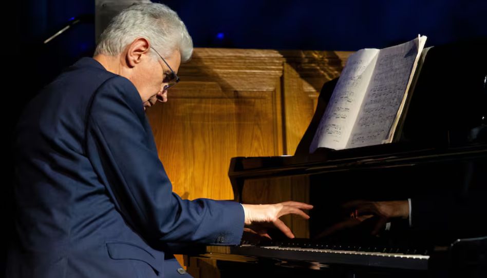 Élder Gérald Caussé tocando piano.
