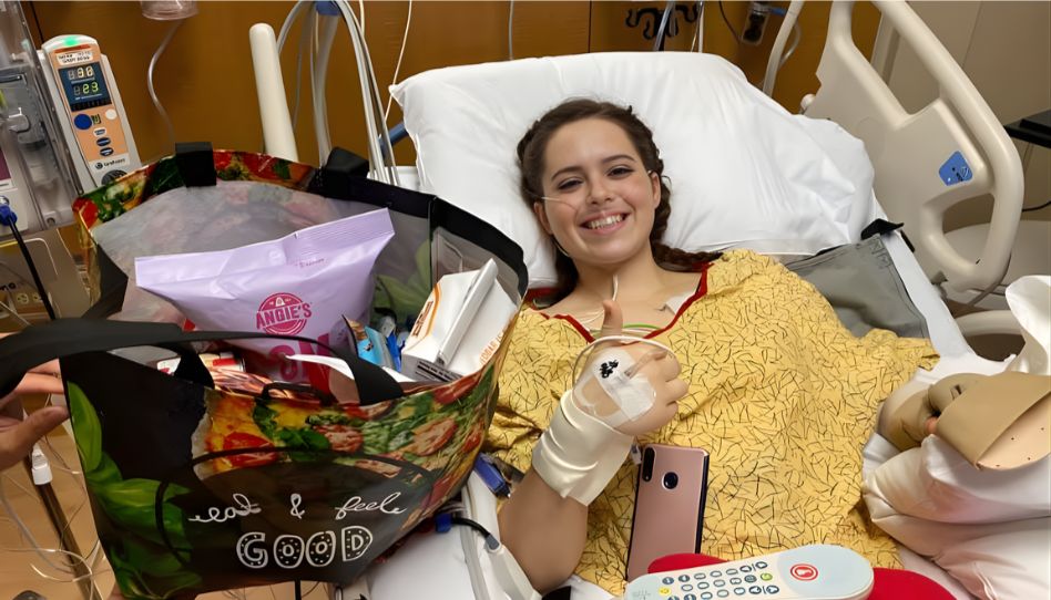 Missionária na cama de hospital com semblante feliz após sobreviver a 9 facadas.