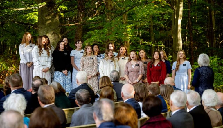 Missionárias cantam “A Primeira Oração de Joseph Smith” durante uma devoção matinal no Bosque Sagrado