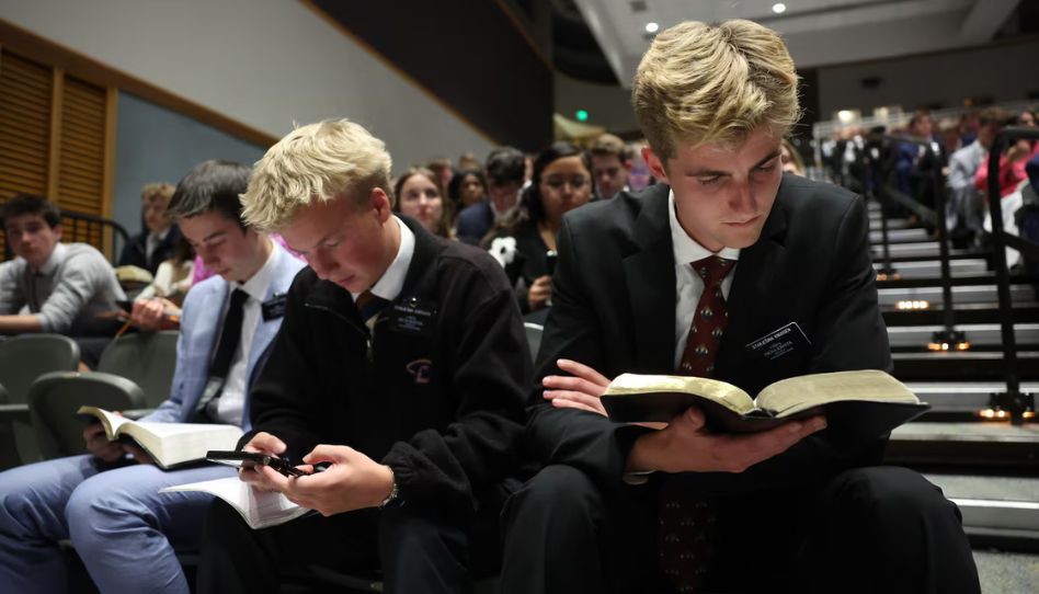 Um missionário lê uma passagem das escrituras - sucessão de um profeta.