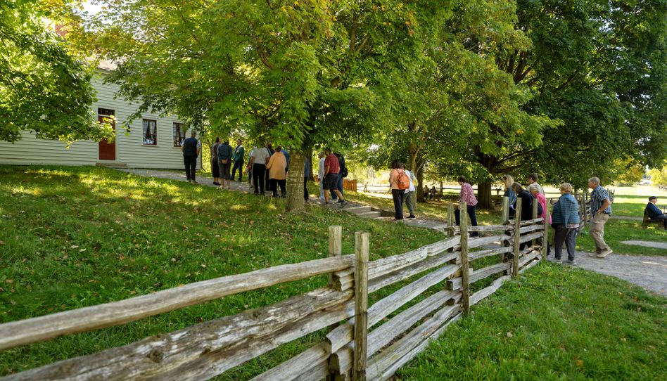 Visitantes se aproximam da Casa de Madeira da família Joseph Smith, perto do Bosque Sagrado