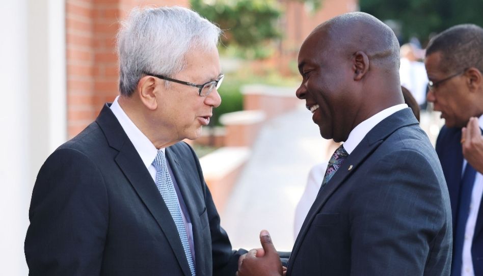 Élder Gong conversando com um irmão durante a dedicação do templo de Harare Zimbábue.