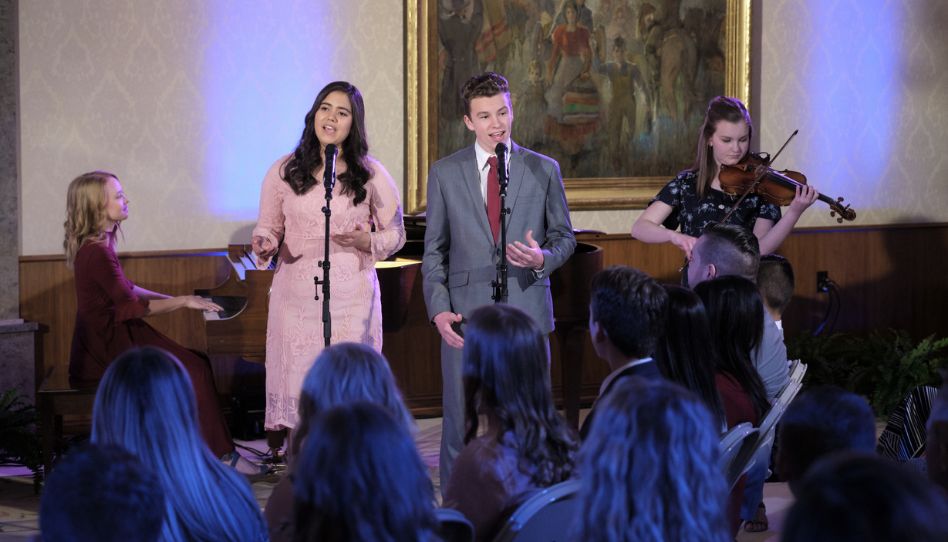 Jovens Santos dos Últimos Dias cantas e tocam durante devocional musical.